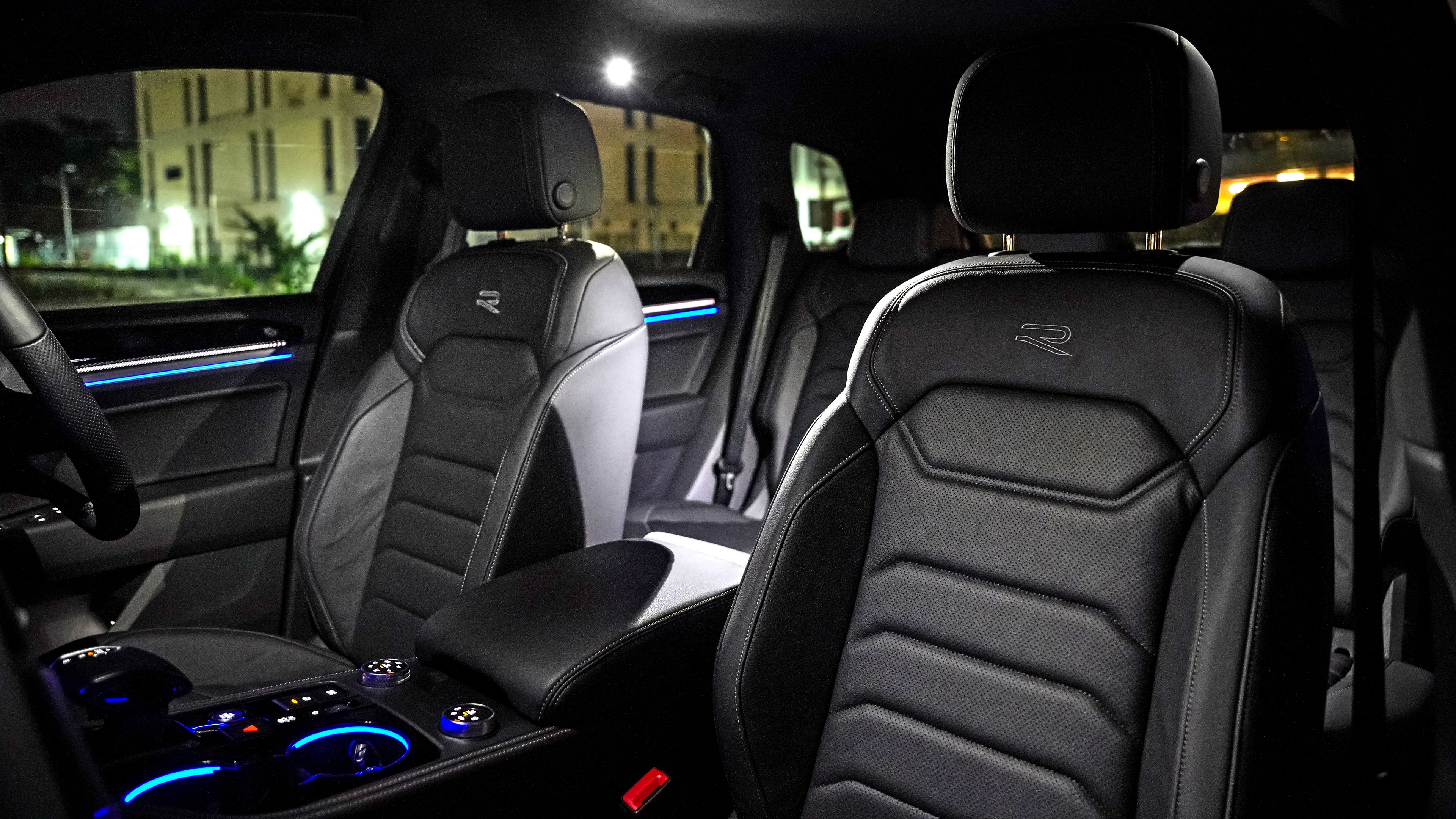 Volkswagen Touareg R-Line | Active climate seats Illuminated Volkswagen Touareg R-Line interior at night showcasing modern design and ambient lighting.