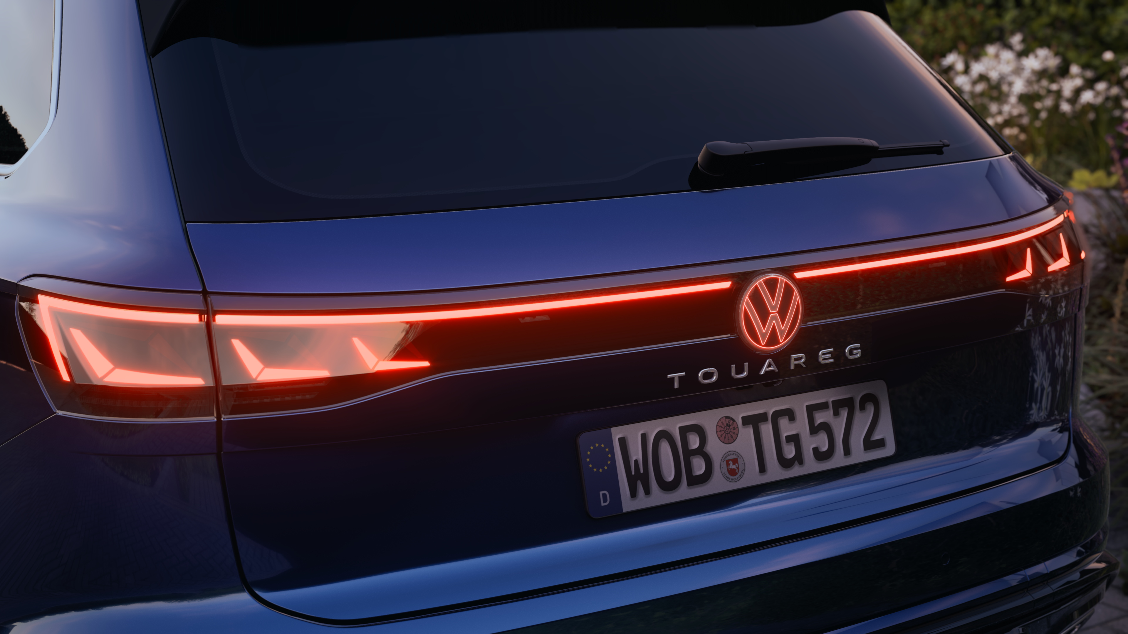 Volkswagen Touareg R-Line | LED rear combination lamps Close-up of the Volkswagen Touareg R-Line's rear with distinctive tail lights illuminated at dusk.