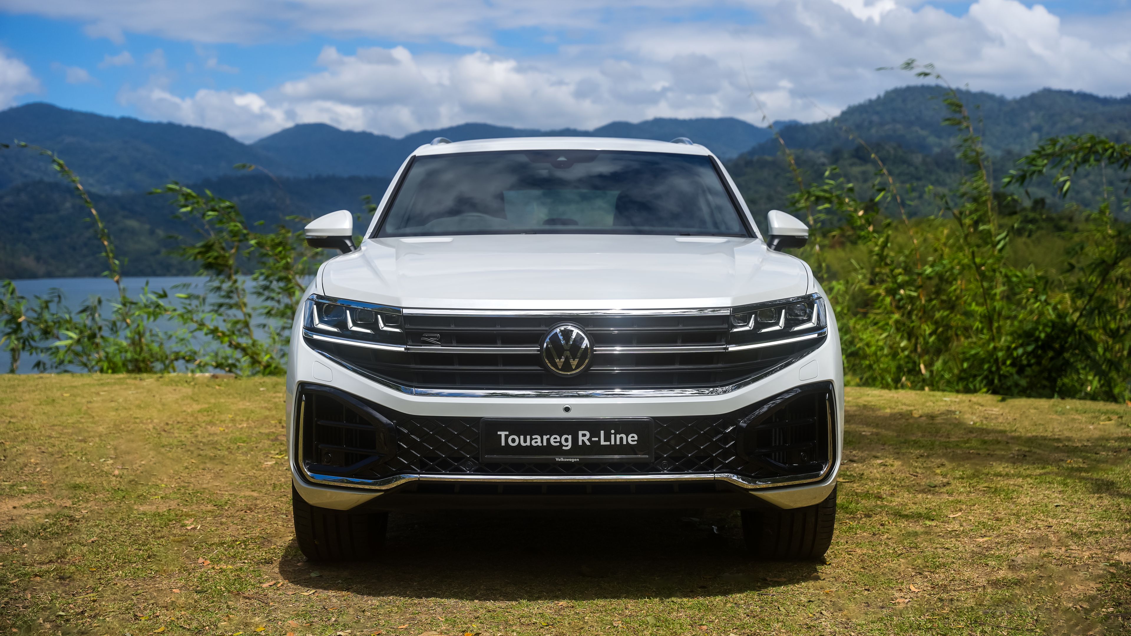 Volkswagen Touareg R-Line | Exterior White Volkswagen Touareg R-Line parked in front of scenic mountains and clouds.